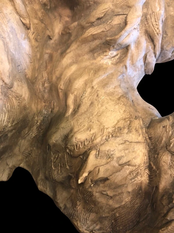 Sculpture représentant un couple de chiens en terre cuite, avec un socle en bois.