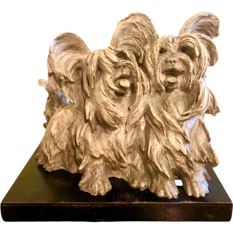 Sculpture représentant un couple de chiens en terre cuite, avec un socle en bois.