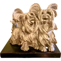 Sculpture représentant un couple de chiens en terre cuite, avec un socle en bois.
