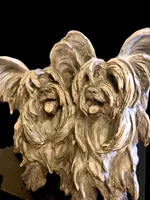 Sculpture représentant un couple de chiens en terre cuite, avec un socle en bois.