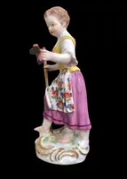 Sculturina in porcellana,figura di contadina con bastone e grappolo d’uva.Meissen.