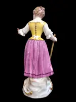 Sculturina in porcellana,figura di contadina con bastone e grappolo d’uva.Meissen.