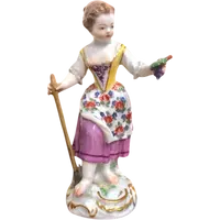 Sculturina in porcellana,figura di contadina con bastone e grappolo d’uva.Meissen.