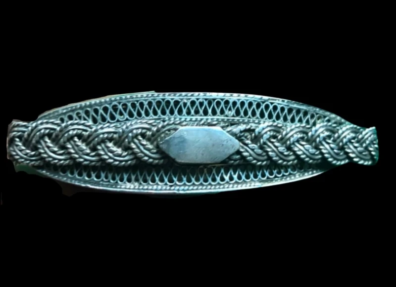Silver filigree card holder featuring plant motifs and stylized scrolls.