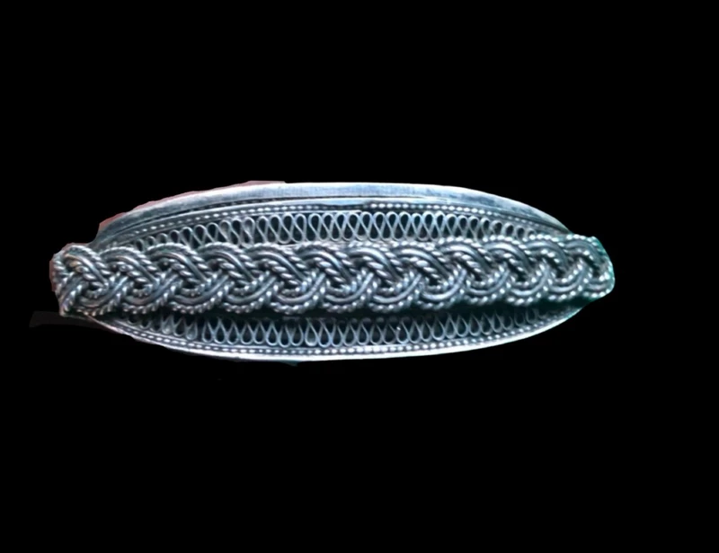 Silver filigree card holder featuring plant motifs and stylized scrolls.