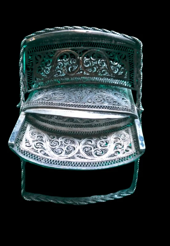 Silver filigree card holder featuring plant motifs and stylized scrolls.