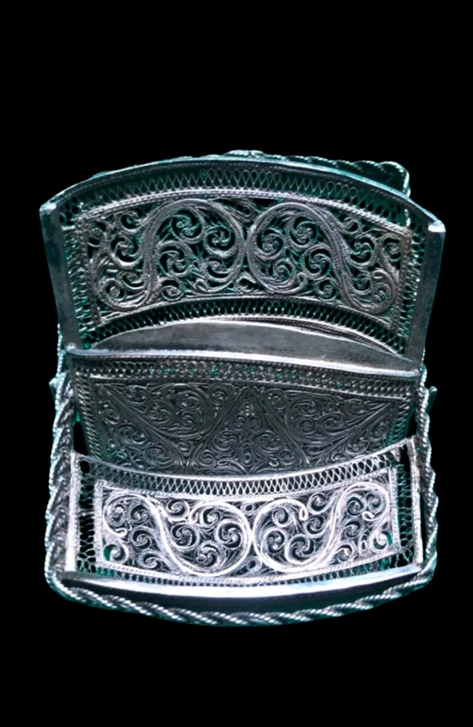 Silver filigree card holder featuring plant motifs and stylized scrolls.