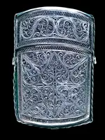 Silver filigree card holder featuring plant motifs and stylized scrolls.