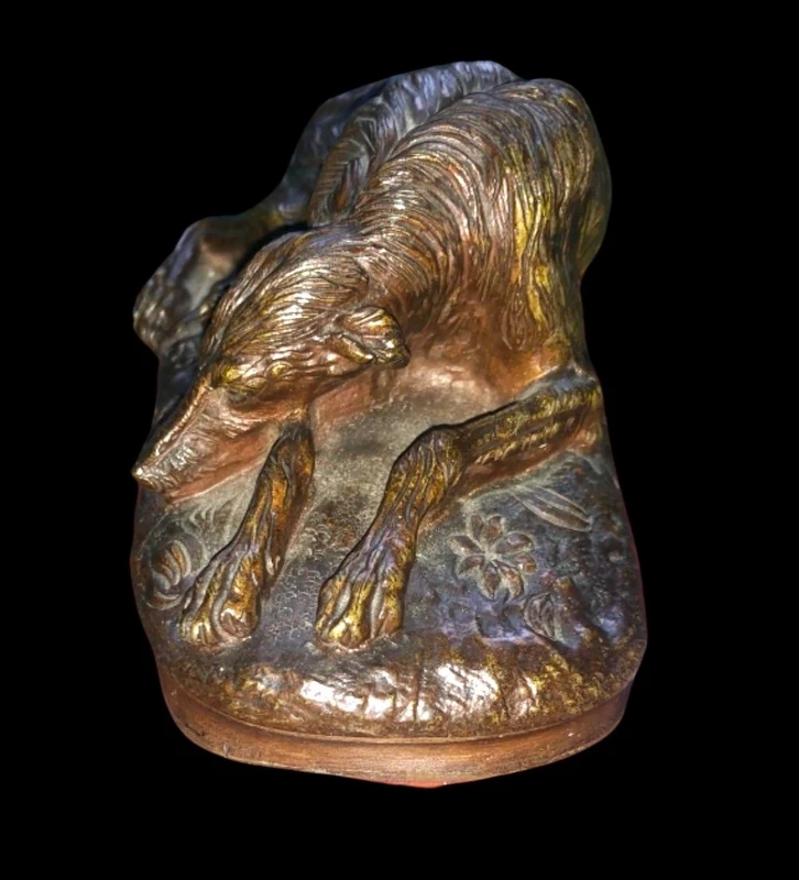 Bronze sculpture on a marble base depicting a sleeping greyhound. Signed