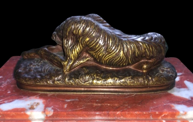 Bronze sculpture on a marble base depicting a sleeping greyhound. Signed