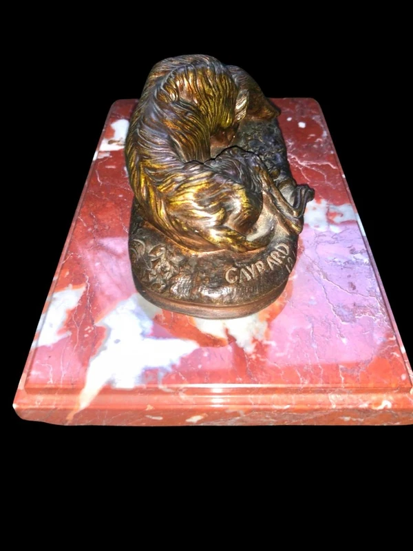 Bronze sculpture on a marble base depicting a sleeping greyhound. Signed