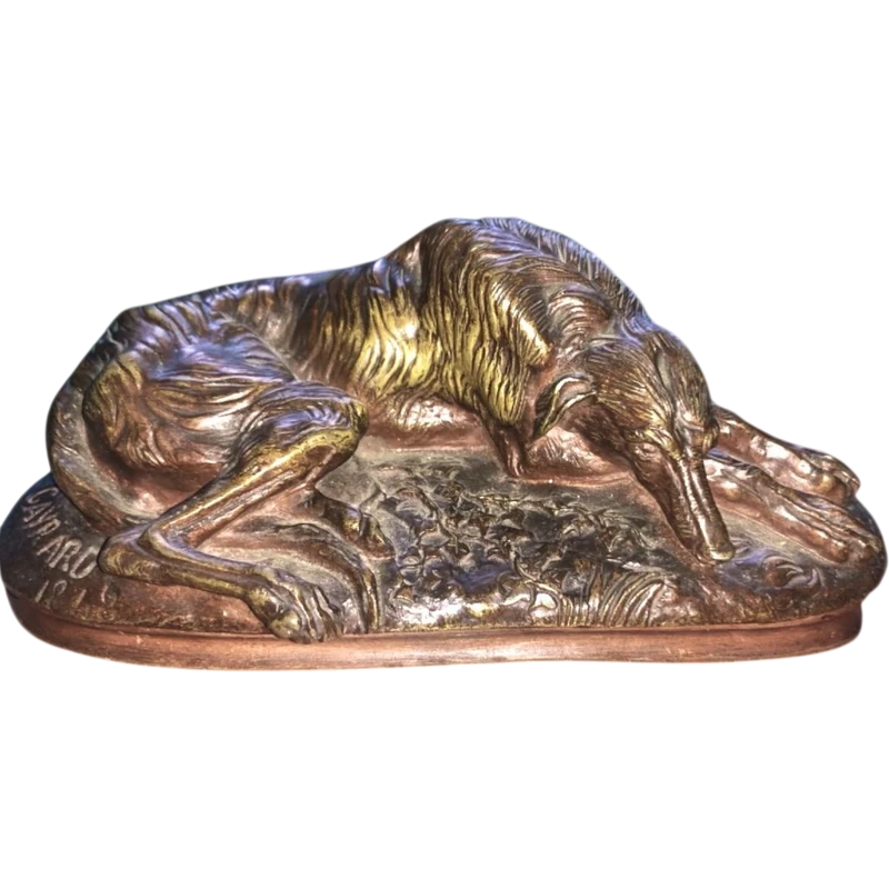 Bronze sculpture on a marble base depicting a sleeping greyhound. Signed