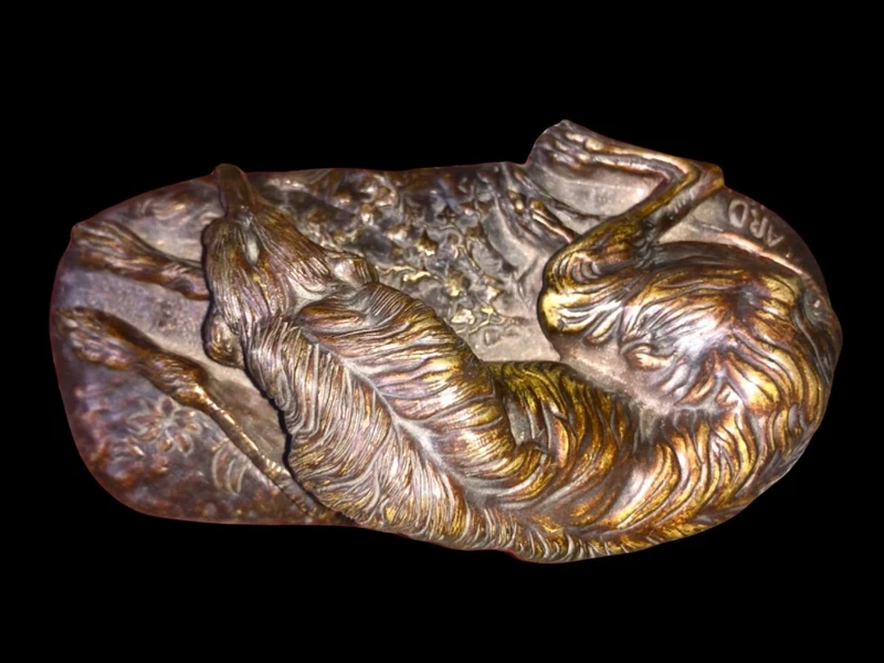 Bronze sculpture on a marble base depicting a sleeping greyhound. Signed