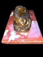 Bronze sculpture on a marble base depicting a sleeping greyhound. Signed