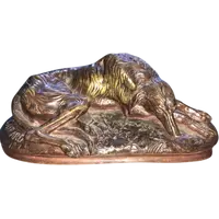 Bronze sculpture on a marble base depicting a sleeping greyhound. Signed