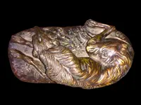 Bronze sculpture on a marble base depicting a sleeping greyhound. Signed