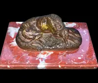 Bronze sculpture on a marble base depicting a sleeping greyhound. Signed