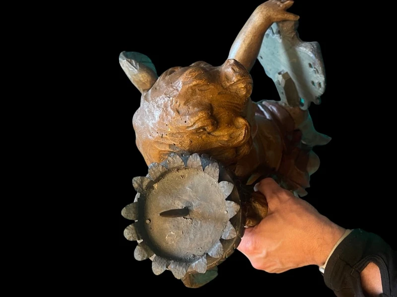 Polychrome wooden sculpture depicting an angel holding a candlestick and a rocaille shield