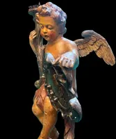 Polychrome wooden sculpture depicting an angel holding a candlestick and a rocaille shield