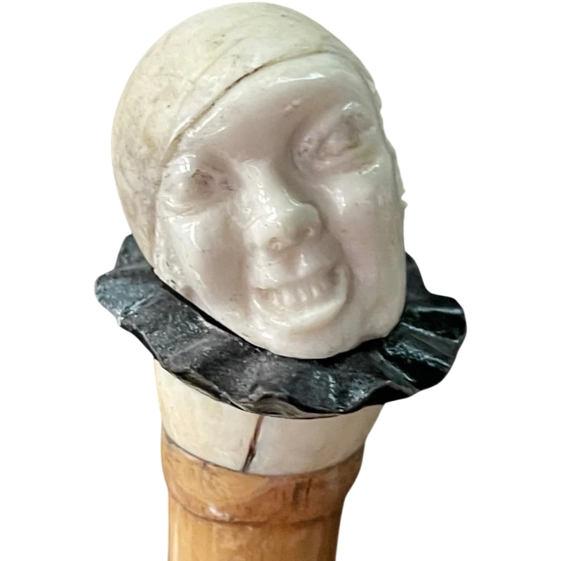 bastone con pomolo in avorio e ebano raffigurante testa di Pierrot con espressione  grottesca.