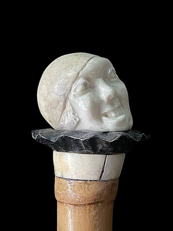 bastone con pomolo in avorio e ebano raffigurante testa di Pierrot con espressione  grottesca.