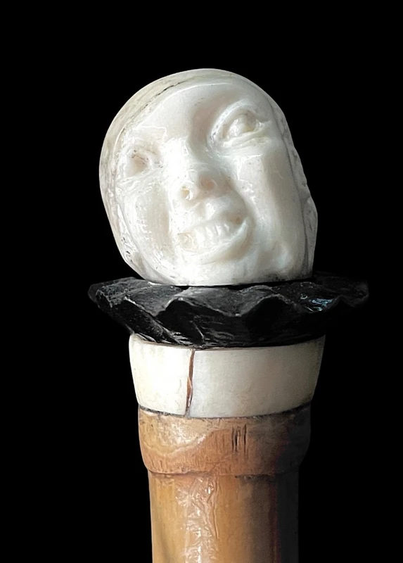 bastone con pomolo in avorio e ebano raffigurante testa di Pierrot con espressione  grottesca.