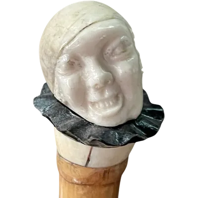 bastone con pomolo in avorio e ebano raffigurante testa di Pierrot con espressione  grottesca.