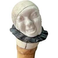 bastone con pomolo in avorio e ebano raffigurante testa di Pierrot con espressione  grottesca.