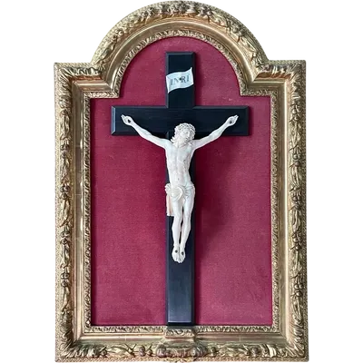 Christ en ivoire sur une croix en ébène, avec un cadre mouluré recouvert de feuilles d'or.