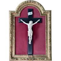 Cristo in avorio su croce in ebano e cornice sagomata in foglia oro.