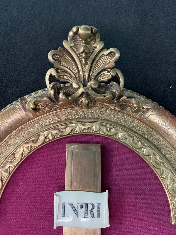 An ivory statue of Christ with a molded frame featuring floral motifs, rocaille, and gold leaf.