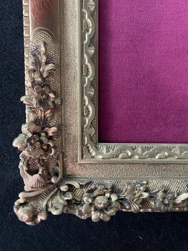 An ivory statue of Christ with a molded frame featuring floral motifs, rocaille, and gold leaf.