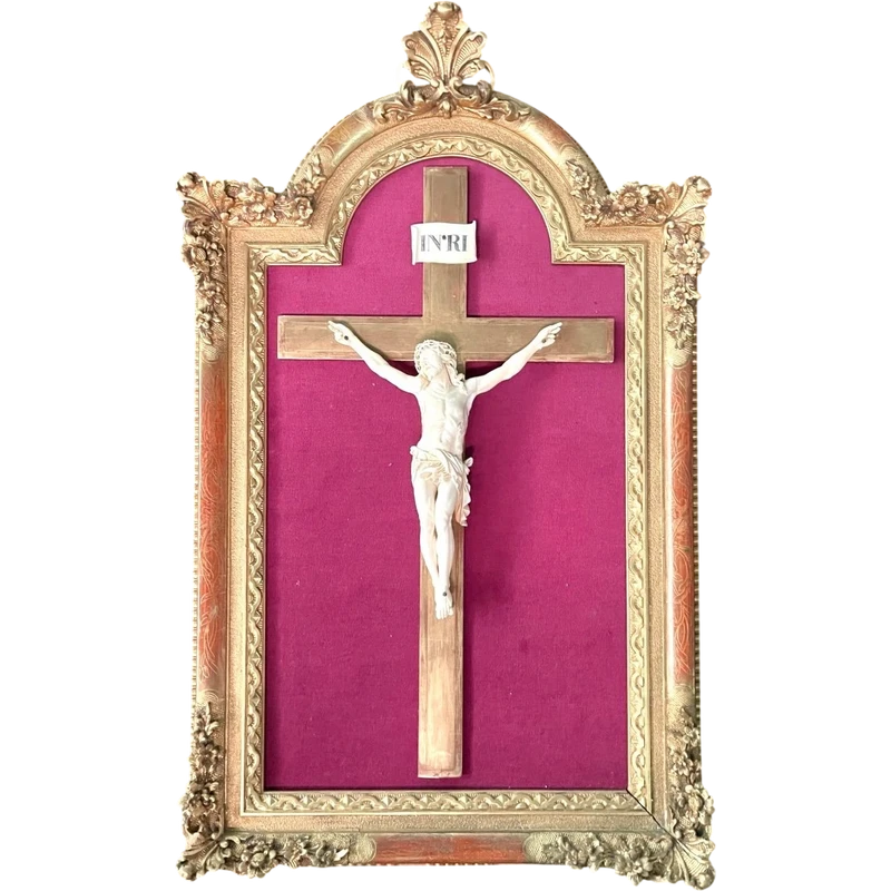An ivory statue of Christ with a molded frame featuring floral motifs, rocaille, and gold leaf.