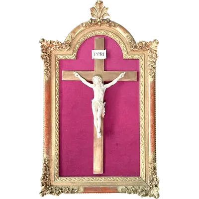 An ivory statue of Christ with a molded frame featuring floral motifs, rocaille, and gold leaf.