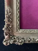An ivory statue of Christ with a molded frame featuring floral motifs, rocaille, and gold leaf.