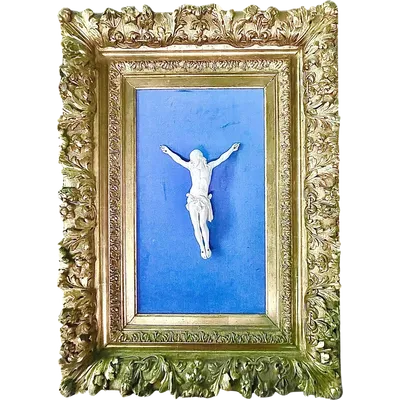 An ivory statue of Christ with a carved and gilded wooden frame featuring plant motifs.