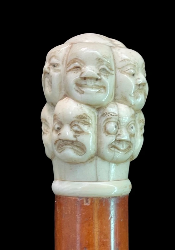 A walking stick with an ivory knob carved in the round with Commedia dell’Arte masks.
