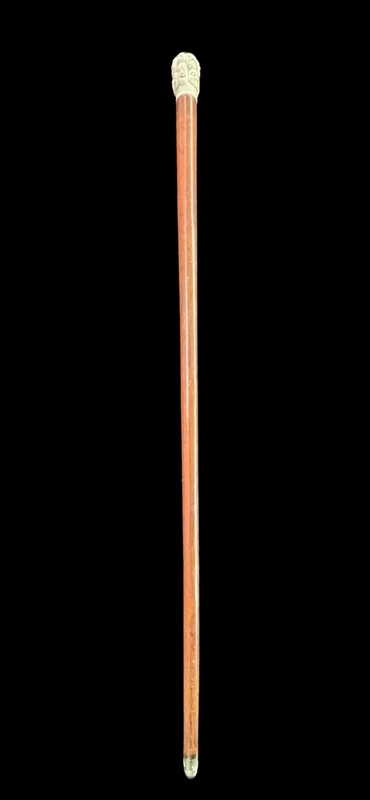 A walking stick with an ivory knob carved in the round with Commedia dell’Arte masks.