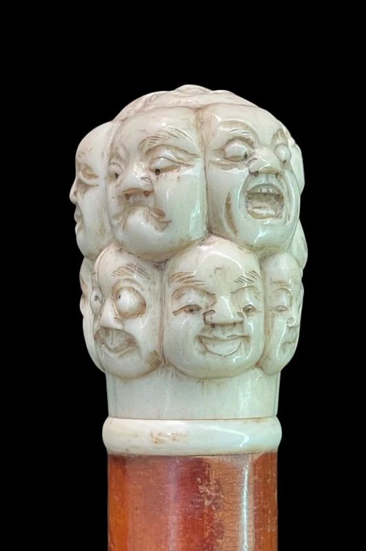 A walking stick with an ivory knob carved in the round with Commedia dell’Arte masks.