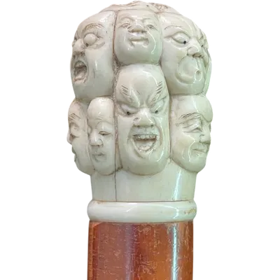 A walking stick with an ivory knob carved in the round with Commedia dell’Arte masks.