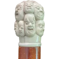 A walking stick with an ivory knob carved in the round with Commedia dell’Arte masks.