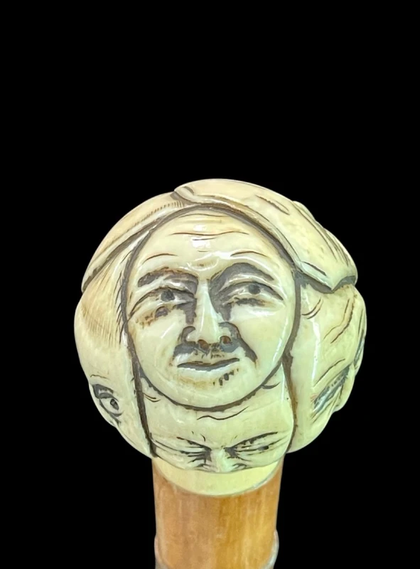Cane with a round ivory knob carved with Commedia dell'Arte masks. Japan.