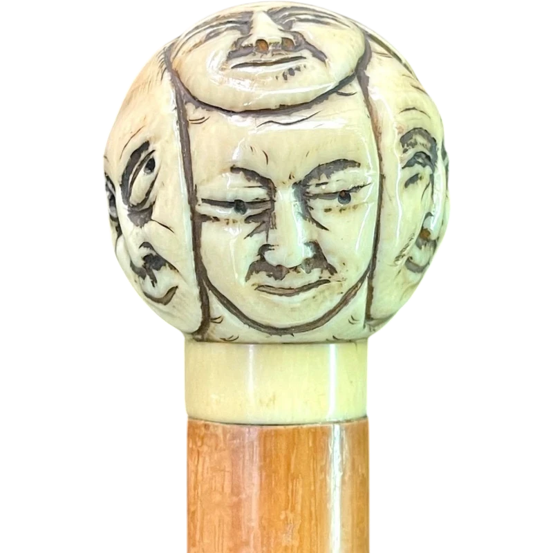 Cane with a round ivory knob carved with Commedia dell'Arte masks. Japan.
