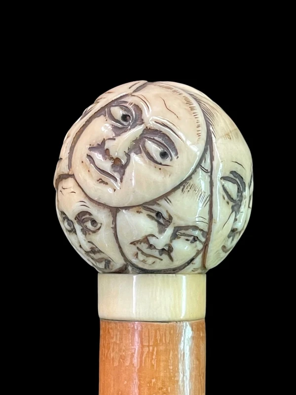 Cane with a round ivory knob carved with Commedia dell'Arte masks. Japan.