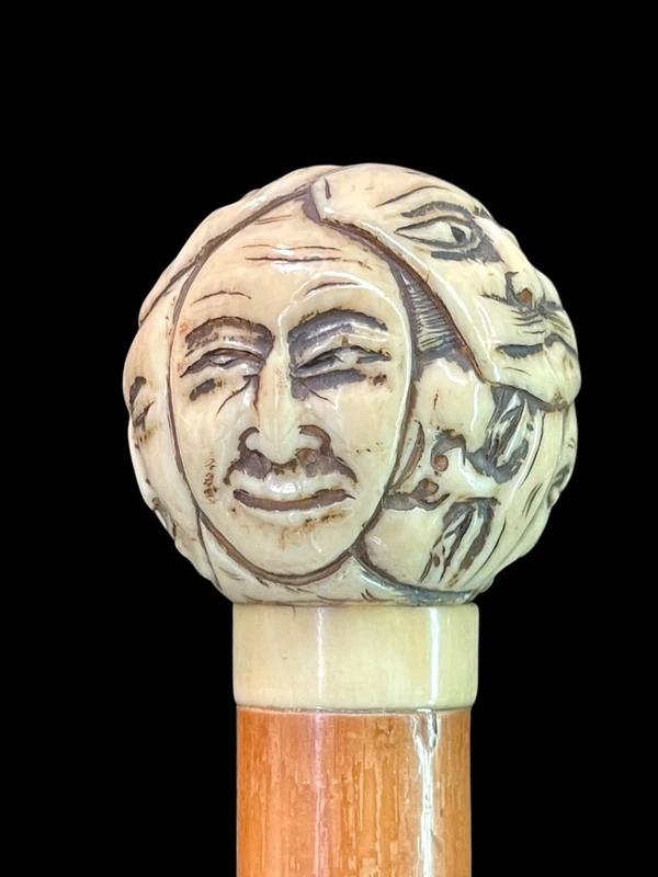 Cane with a round ivory knob carved with Commedia dell'Arte masks. Japan.