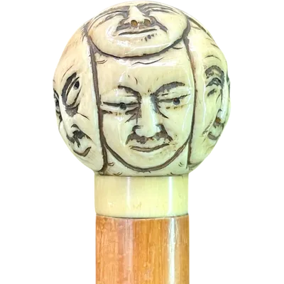 Cane with a round ivory knob carved with Commedia dell'Arte masks. Japan.