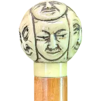 Cane with a round ivory knob carved with Commedia dell'Arte masks. Japan.
