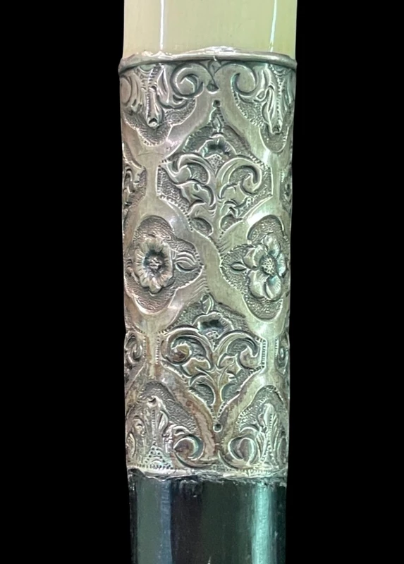 An ivory "evening" cane with tips and embossed silver featuring rocaille motifs