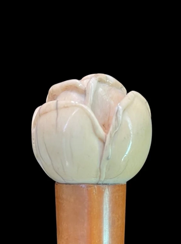 A walking stick with an ivory knob depicting a rose.
