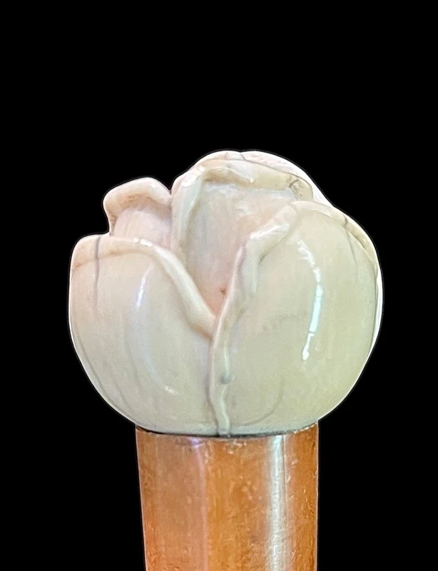 A walking stick with an ivory knob depicting a rose.